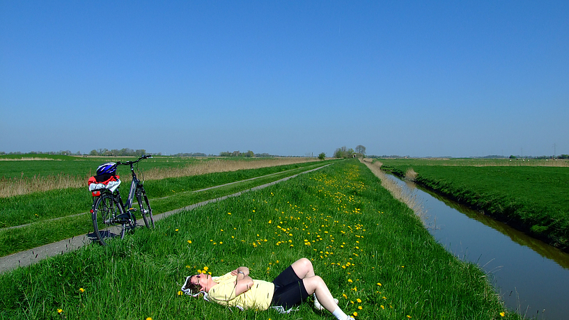 Pause in weiter Landschaft unter hohem Himmel